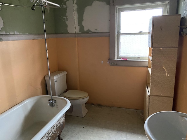 bathroom featuring toilet, a bathing tub, and tile patterned floors