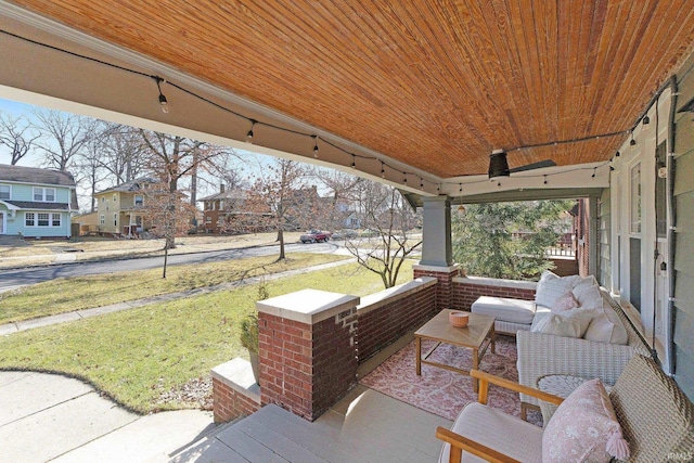 wooden deck featuring covered porch and a lawn