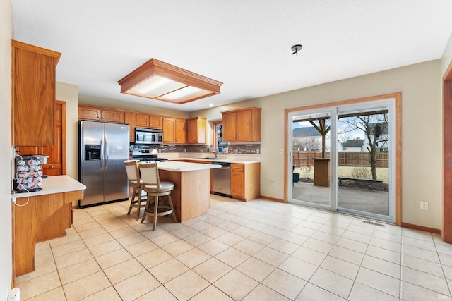 kitchen featuring a sink, visible vents, light countertops, appliances with stainless steel finishes, and backsplash