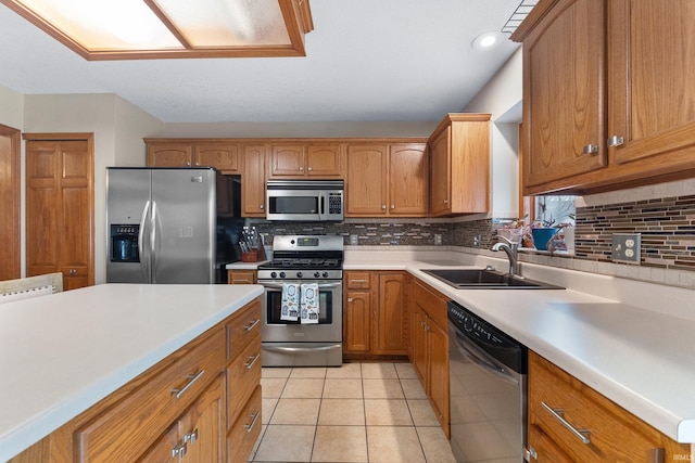 kitchen with decorative backsplash, appliances with stainless steel finishes, light countertops, and a sink