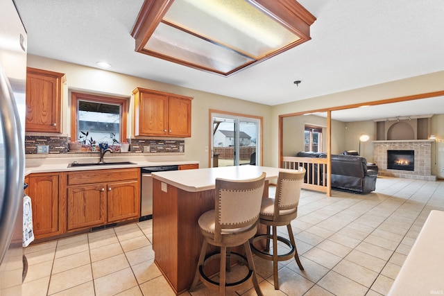 kitchen with light tile patterned floors, appliances with stainless steel finishes, plenty of natural light, and a sink