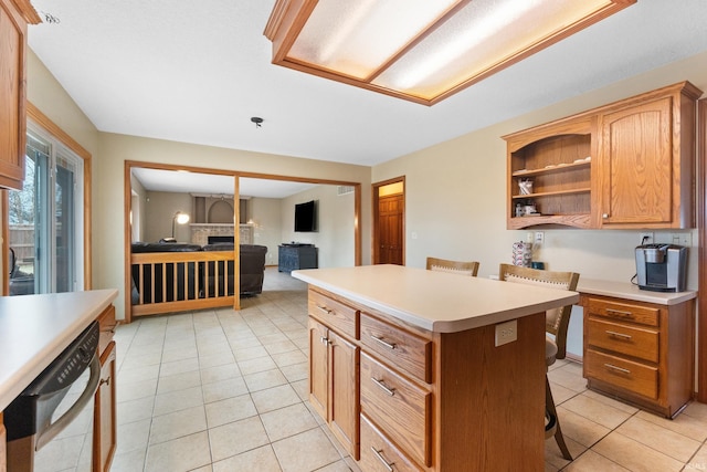 kitchen with dishwashing machine, a kitchen island, light countertops, a kitchen bar, and light tile patterned flooring