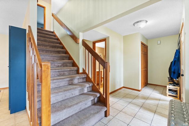 stairway featuring baseboards and tile patterned floors