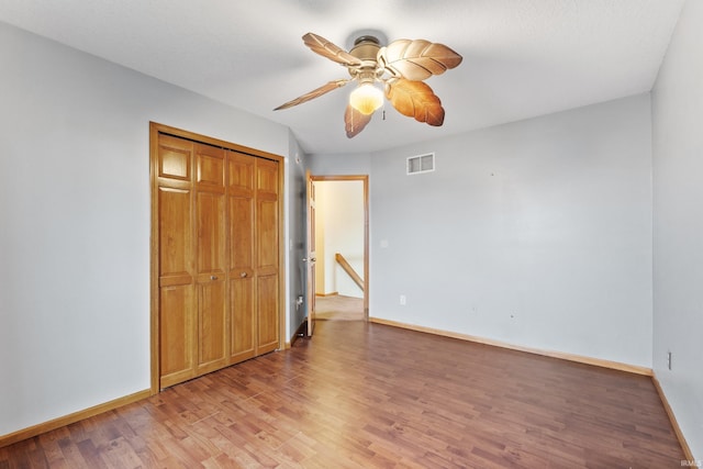 unfurnished bedroom featuring a closet, light wood-type flooring, visible vents, and baseboards