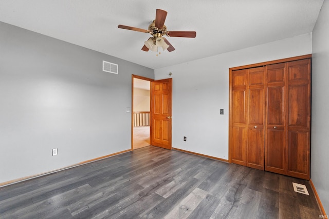 unfurnished bedroom featuring ceiling fan, dark wood-style flooring, visible vents, and baseboards