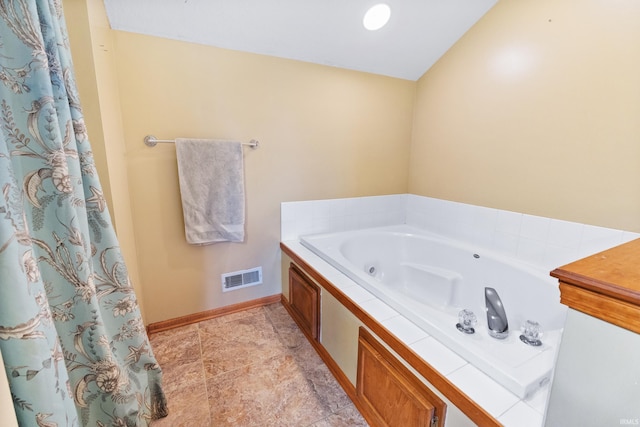 bathroom featuring a whirlpool tub, baseboards, and visible vents