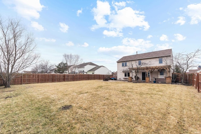 rear view of house with a fenced backyard and a lawn