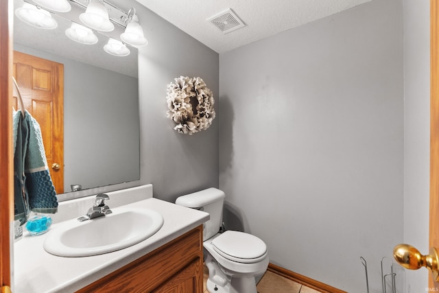 bathroom with visible vents, toilet, a textured ceiling, vanity, and tile patterned flooring