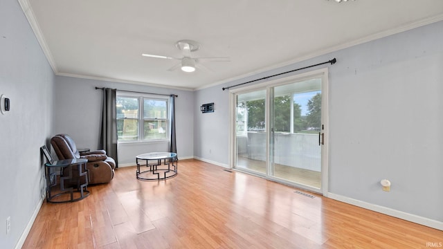 sitting room with visible vents, crown molding, baseboards, and wood finished floors