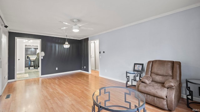 sitting room featuring visible vents, crown molding, light wood-style flooring, and baseboards