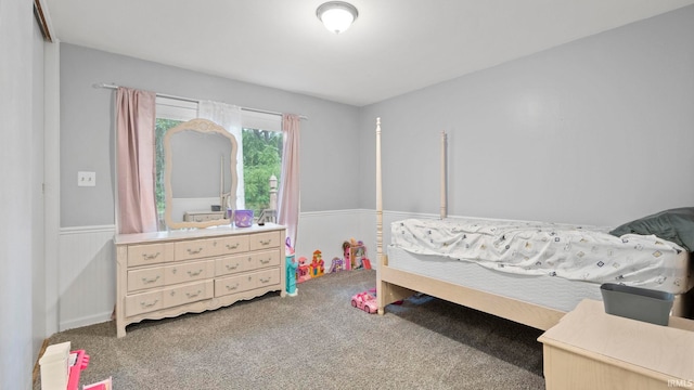 bedroom featuring carpet and a wainscoted wall