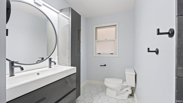 bathroom with tile patterned flooring, toilet, and baseboards