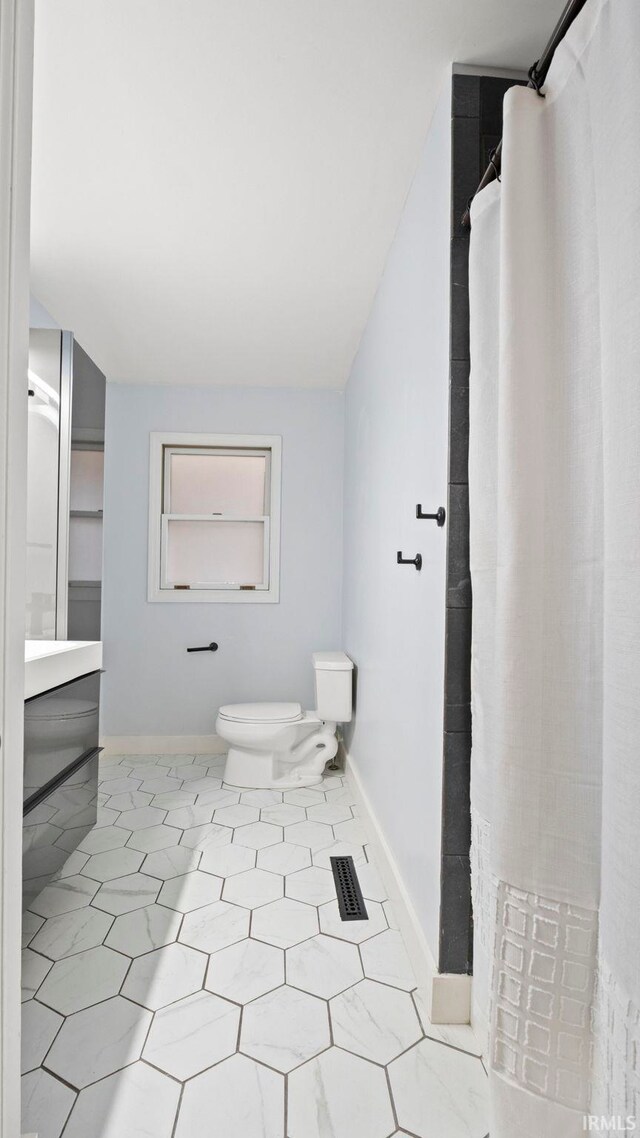 full bath featuring lofted ceiling, toilet, visible vents, and baseboards