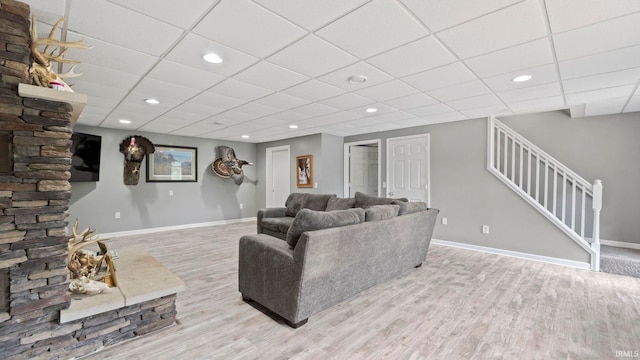 living room featuring stairway, baseboards, and wood finished floors