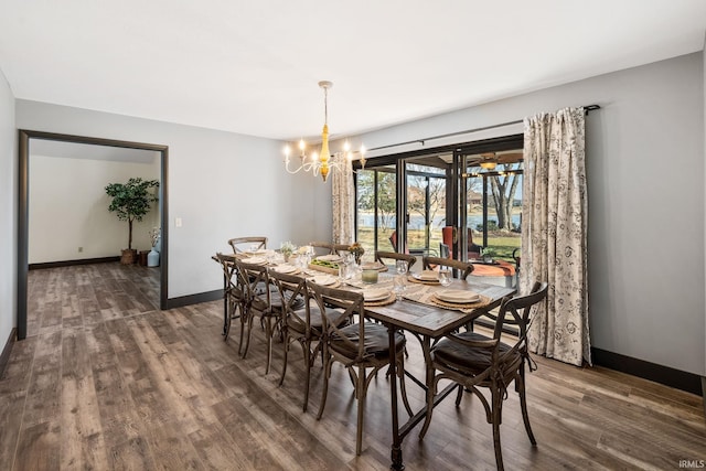 dining area featuring baseboards, a chandelier, and wood finished floors