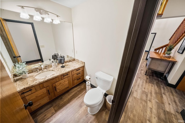 bathroom with vanity, wood finished floors, and toilet