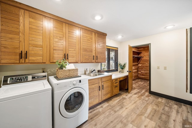 laundry area with recessed lighting, a sink, washer and dryer, light wood-type flooring, and cabinet space