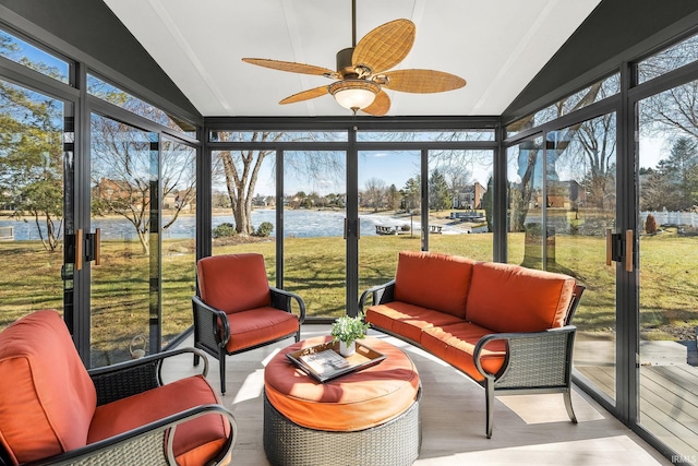 sunroom featuring ceiling fan and a water view