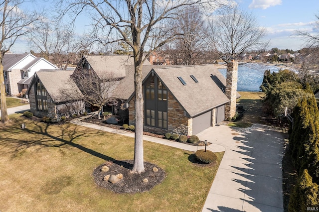 view of front facade featuring a garage, stone siding, a front lawn, and concrete driveway