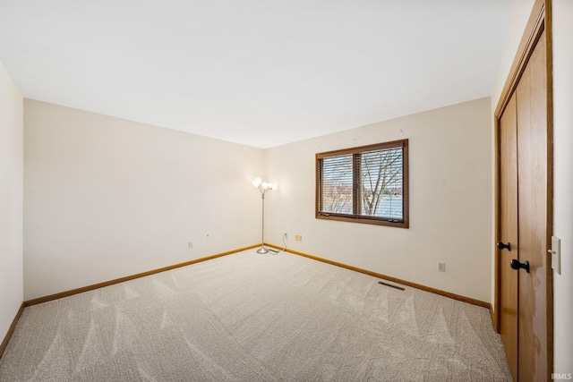 unfurnished bedroom with a closet, carpet flooring, visible vents, and baseboards