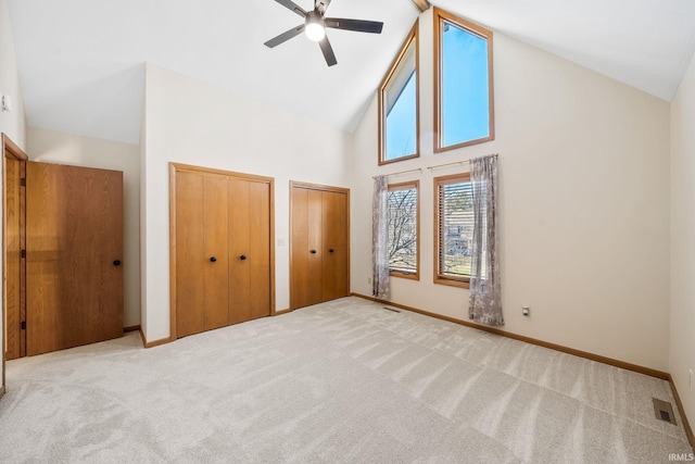 unfurnished bedroom featuring carpet floors, baseboards, visible vents, and multiple closets