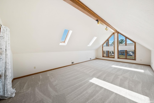 additional living space featuring vaulted ceiling with skylight, carpet, and baseboards