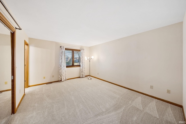 empty room featuring visible vents, baseboards, and carpet flooring