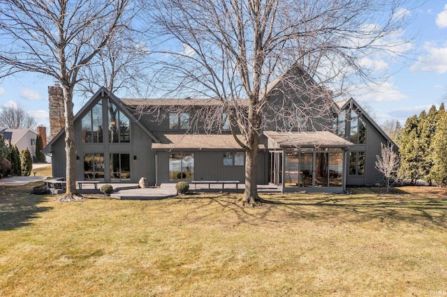 rear view of property with a patio area, a chimney, and a yard