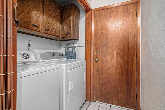 washroom with washing machine and dryer, cabinet space, and light tile patterned floors