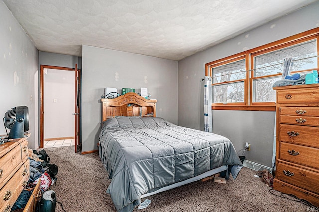 bedroom with a textured ceiling, carpet, and baseboards