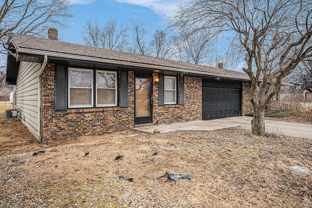 ranch-style house with brick siding, a chimney, concrete driveway, central AC unit, and a garage