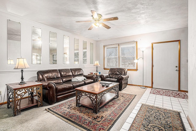 living area featuring ceiling fan, baseboards, a textured ceiling, and tile patterned floors