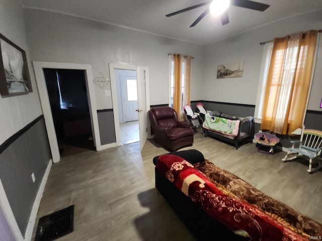 living area featuring ceiling fan, visible vents, and wood finished floors