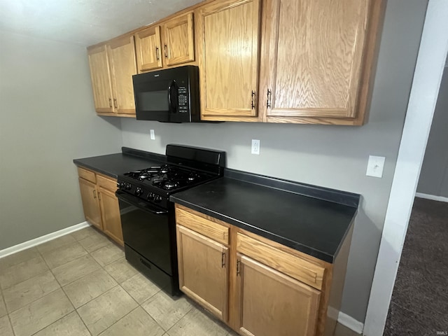 kitchen featuring black appliances, dark countertops, and baseboards