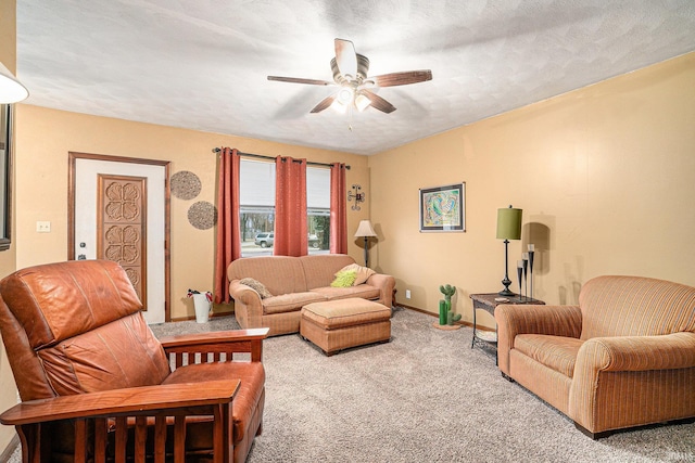 living area featuring carpet, a textured ceiling, baseboards, and a ceiling fan