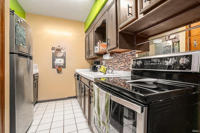 kitchen featuring light tile patterned floors, stainless steel appliances, tasteful backsplash, light countertops, and a sink