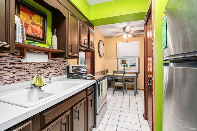 kitchen with tasteful backsplash, light countertops, stainless steel appliances, a sink, and light tile patterned flooring