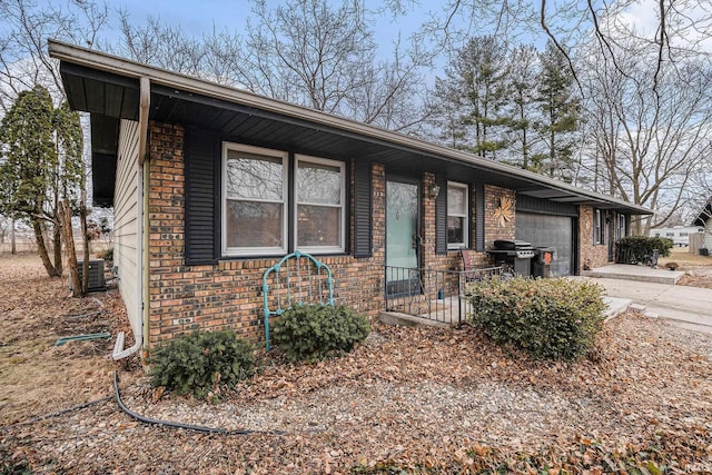 view of front of house featuring a garage, brick siding, and driveway