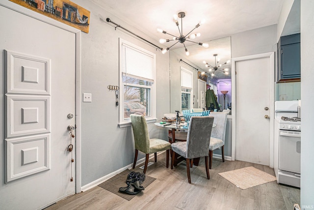 dining room featuring baseboards, a chandelier, and wood finished floors