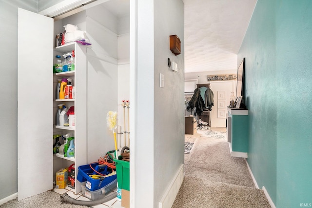 hallway featuring carpet flooring and baseboards