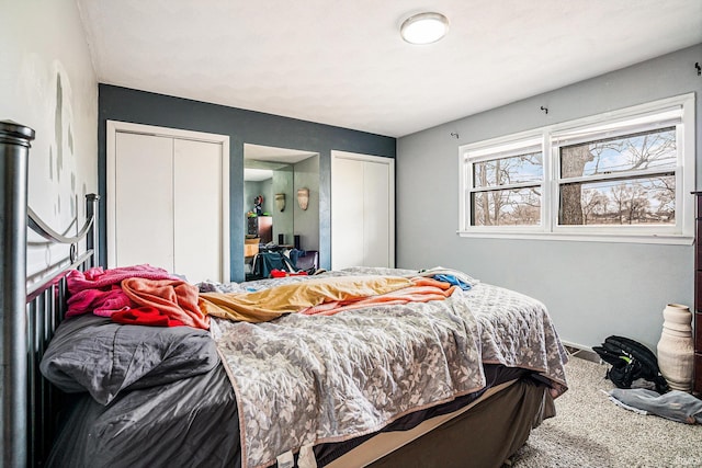 bedroom featuring carpet and two closets