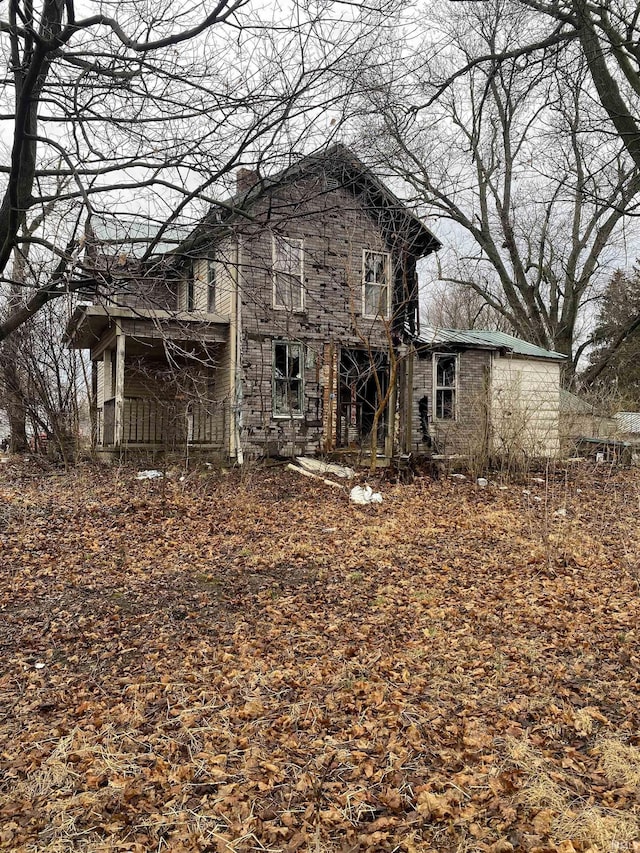 rear view of property featuring a chimney