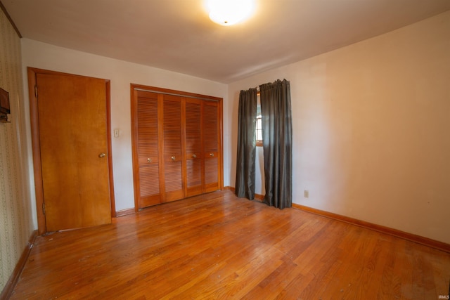 unfurnished bedroom with a closet, light wood-type flooring, and baseboards