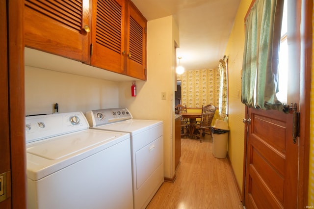 laundry area featuring wallpapered walls, washing machine and dryer, laundry area, and light wood finished floors