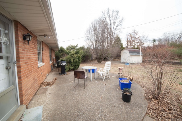 view of patio / terrace with an outbuilding, a shed, and a grill