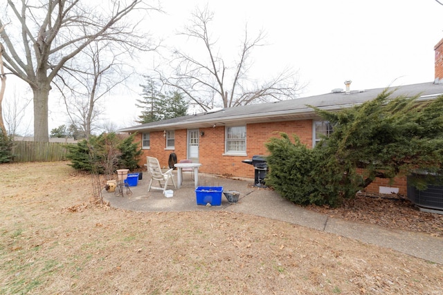 ranch-style house with fence, central AC unit, a patio, and brick siding