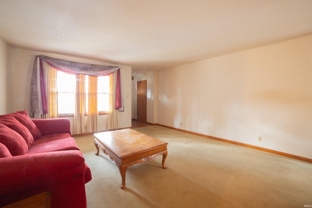 living area featuring light colored carpet and baseboards