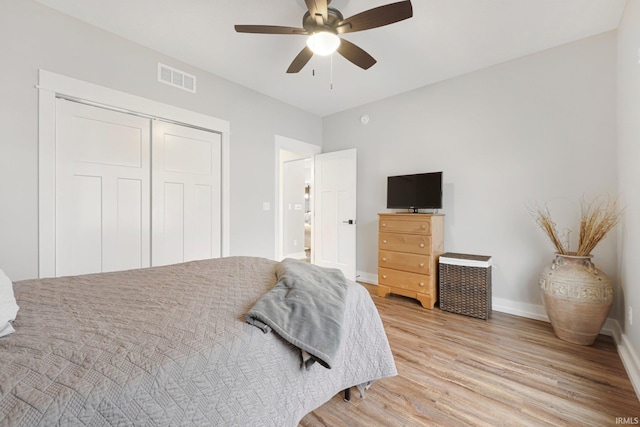 bedroom with visible vents, baseboards, a ceiling fan, light wood-style flooring, and a closet