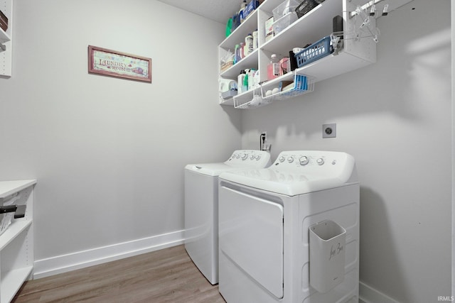 laundry room with light wood-type flooring, laundry area, baseboards, and separate washer and dryer