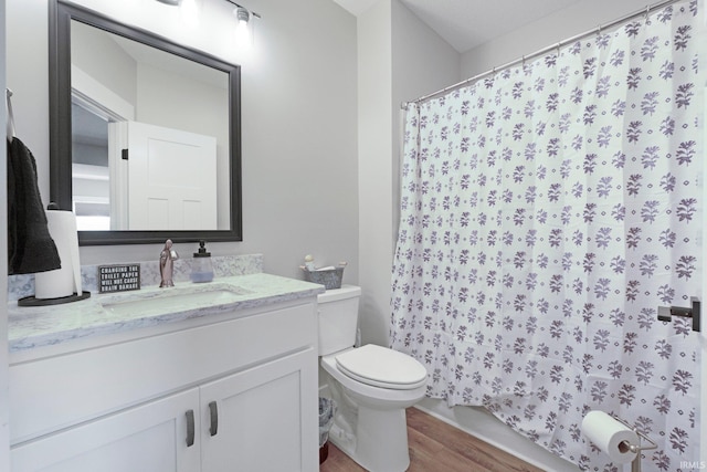 full bath featuring wood finished floors, vanity, toilet, and curtained shower